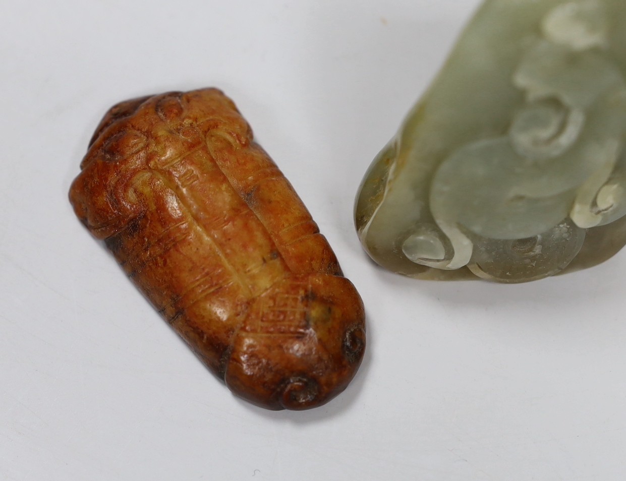 A Chinese green jade 'cash' wheel and a russet jade cicada, a jade pebble carving and a hardstone seal
